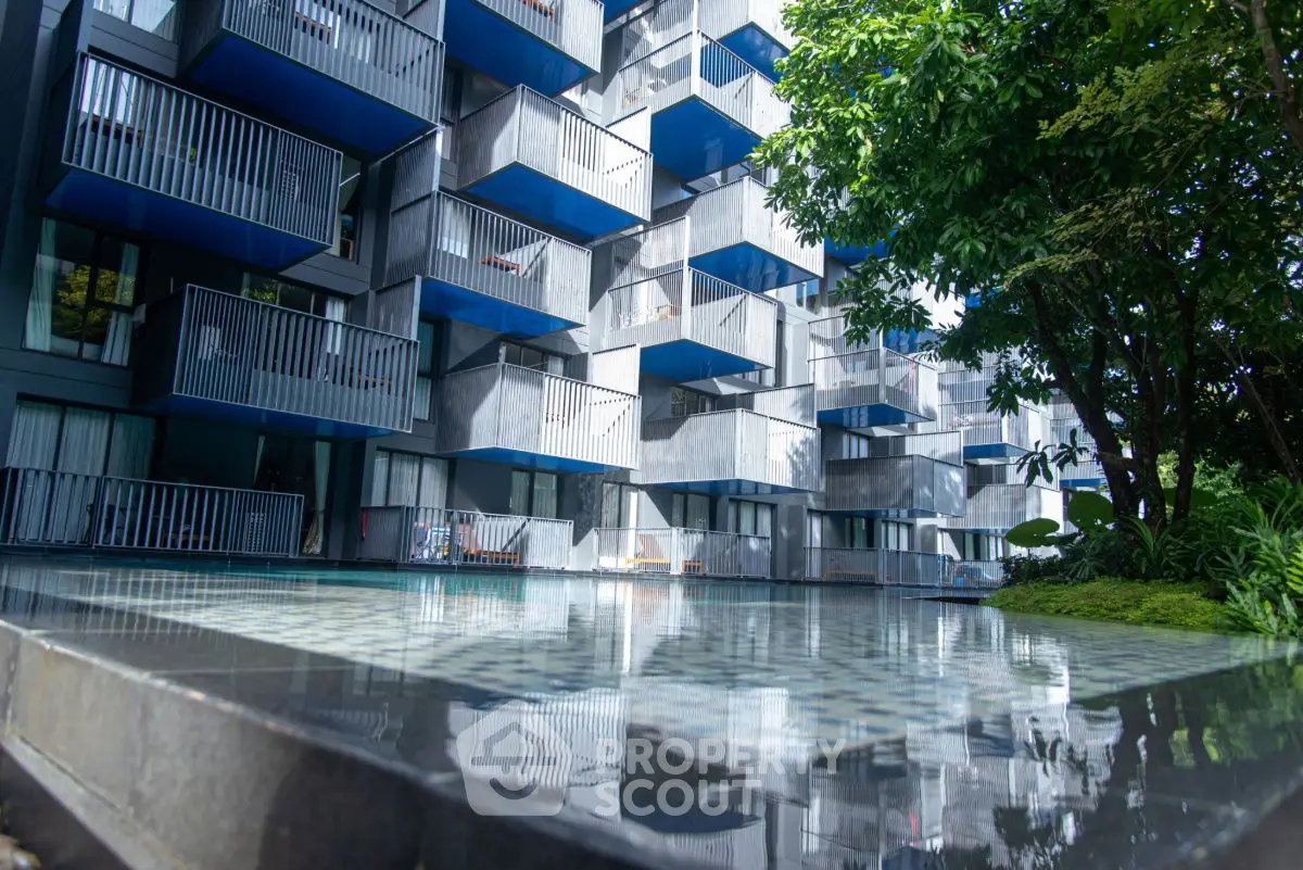 Modern apartment building with unique balcony design and pool view.