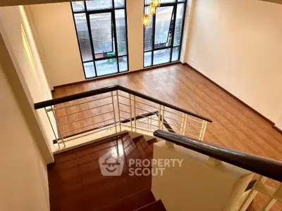 Spacious multi-level living area with high ceilings, large windows, and modern lighting, perfect for entertaining and comfortable living.