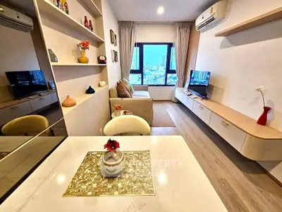 Modern living room with city view, stylish decor, and cozy seating area in a high-rise apartment.