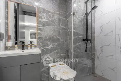 Luxurious modern bathroom with marble tiles and sleek shower design.