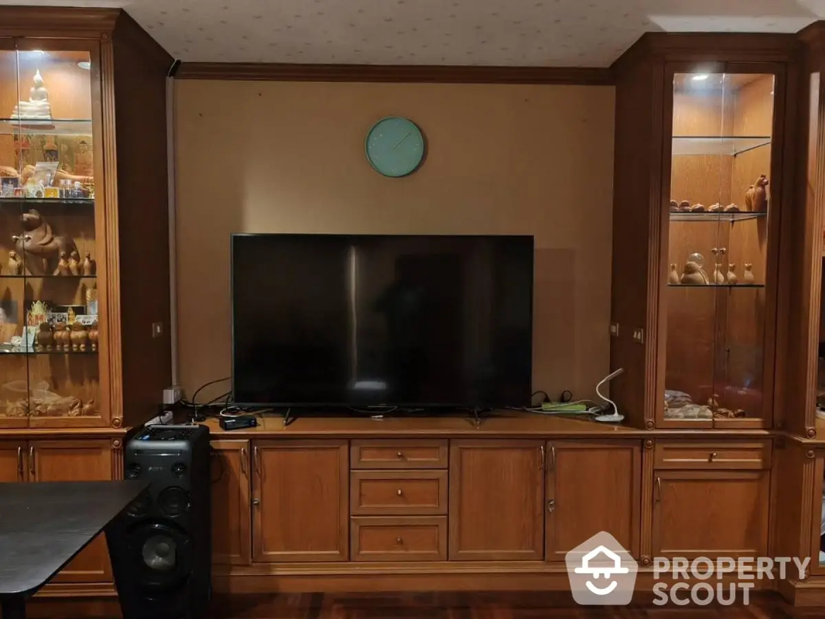 Elegant living room with wooden cabinetry and modern TV setup