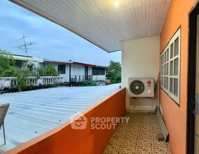 Charming balcony with orange walls and rooftop view, perfect for relaxation.