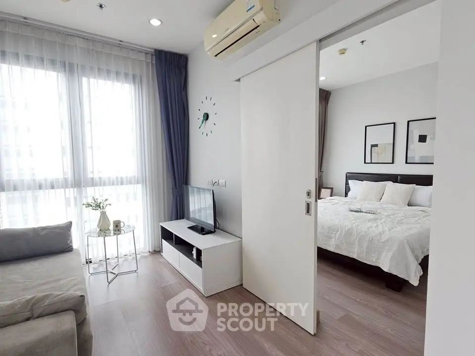 Modern apartment with cozy living room and bedroom, featuring natural light and stylish decor.