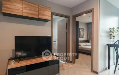 Modern apartment interior with TV, bedroom, and bathroom view.