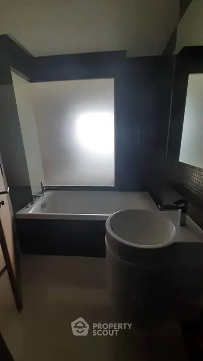 Modern bathroom with sleek fixtures and frosted window for privacy.