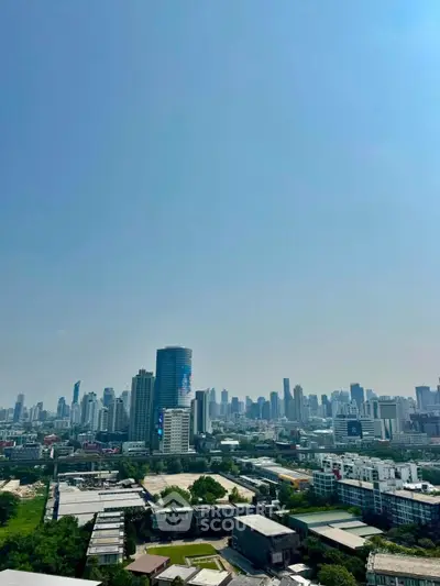 Stunning cityscape view from a high-rise building showcasing urban skyline and greenery.