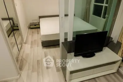 Modern apartment with sleek bedroom and cozy living area featuring a TV and stylish flooring.
