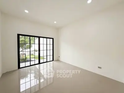 Spacious empty room with large windows and garden view, perfect for customization.