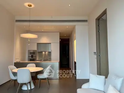 Modern open-plan kitchen and dining area with elegant lighting and sleek furniture.