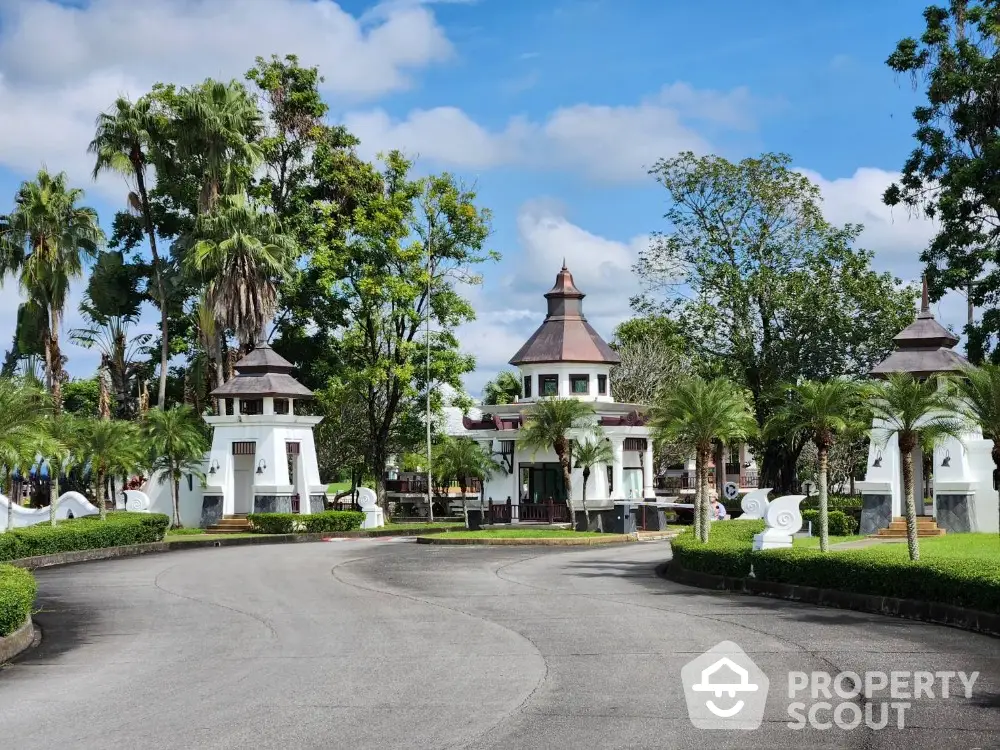 Elegant entrance to luxury estate with lush landscaping and unique architectural design