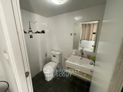 Modern bathroom with sleek fixtures and stylish wall art, featuring a compact design and functional layout.