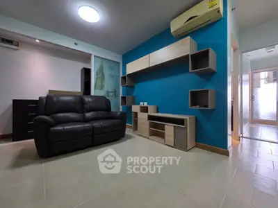 Modern living room with sleek furniture and vibrant blue accent wall