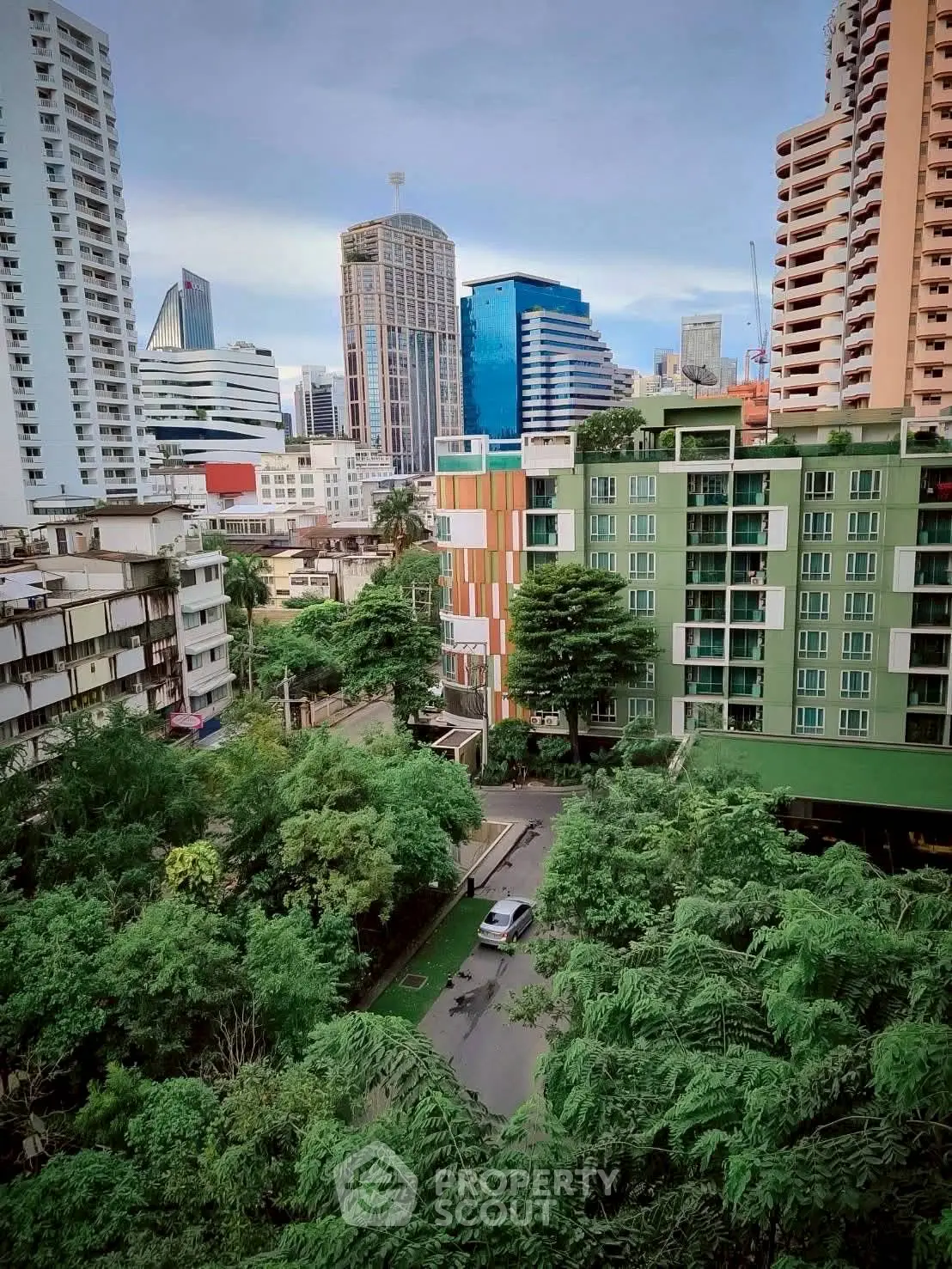 Stunning cityscape view with lush greenery and modern high-rise buildings.