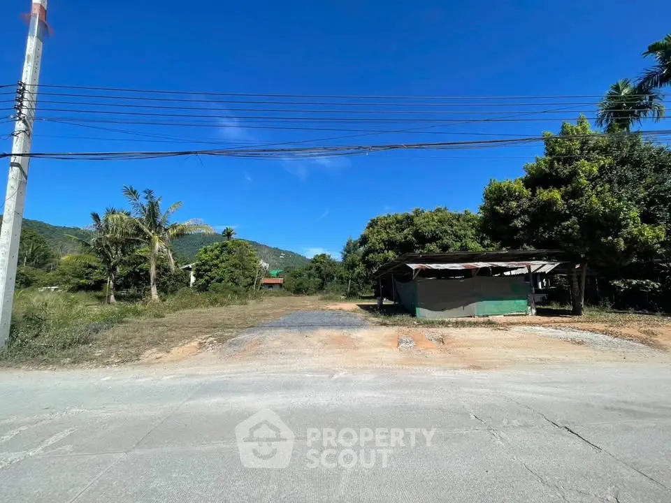 Scenic land plot with lush greenery and mountain views, ideal for development.