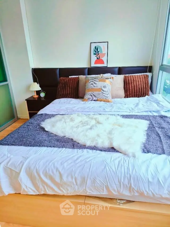 Spacious bedroom with modern decor and large windows for natural light.