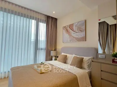 Elegant bedroom with modern decor and large window offering natural light.