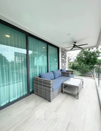 Spacious balcony with modern outdoor furniture and serene view