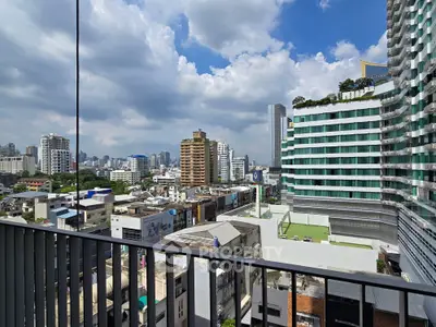 Stunning cityscape view from a high-rise balcony showcasing modern architecture and vibrant urban life.