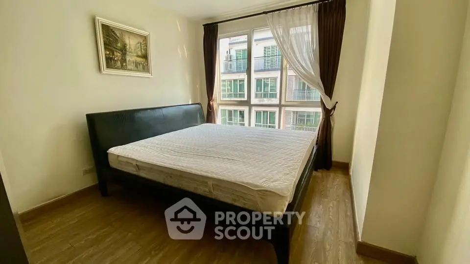 Spacious bedroom with large window and elegant decor in modern apartment