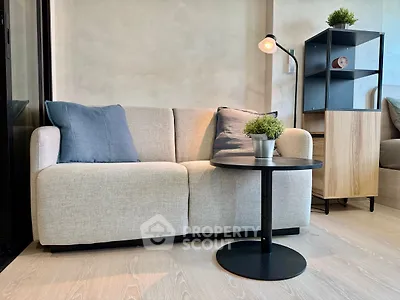 Modern living room with cozy sofa, stylish lamp, and chic decor in a contemporary apartment.