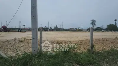 Expansive vacant land plot ready for development with clear skies and potential for residential or commercial projects.