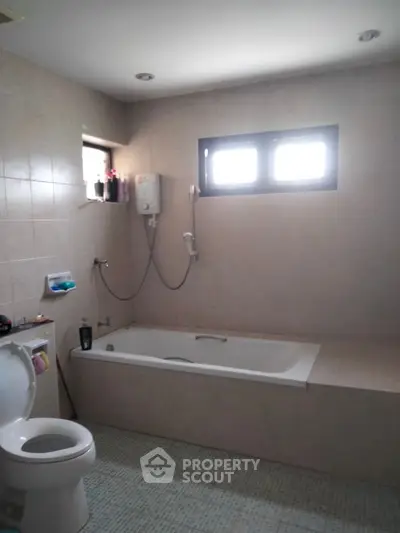 Spacious bathroom with bathtub and modern fixtures in a cozy home.