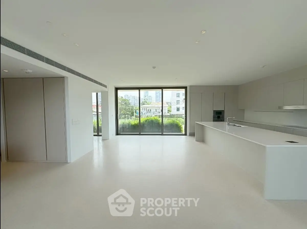 Spacious modern kitchen with open layout and large windows offering city views.