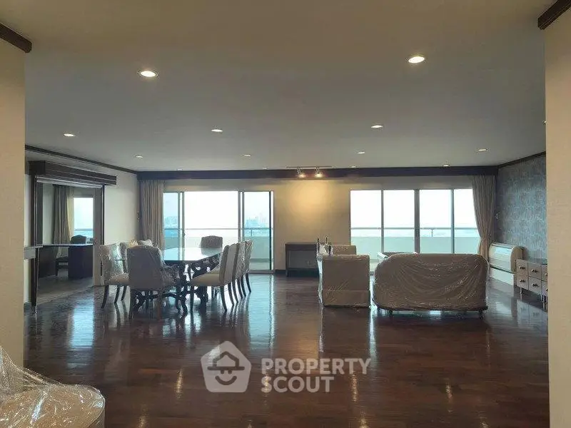 Spacious living room with elegant dining area and large windows offering stunning views.