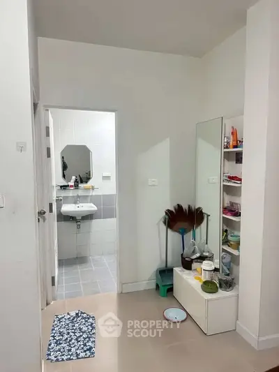 Compact bathroom entrance with mirror and storage, ideal for small apartments.