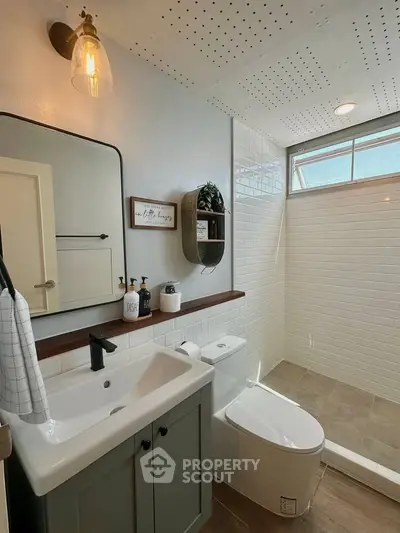 Modern bathroom with sleek fixtures and stylish decor, featuring a spacious shower and elegant vanity.
