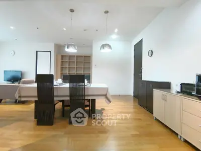 Spacious modern dining area with wooden flooring and stylish furniture in a contemporary apartment.