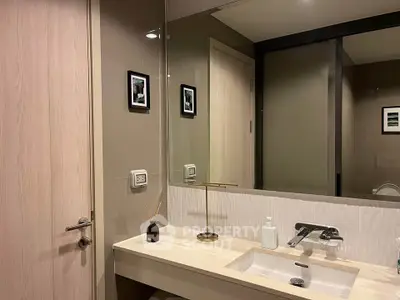 Modern bathroom with sleek sink and stylish decor in contemporary apartment.