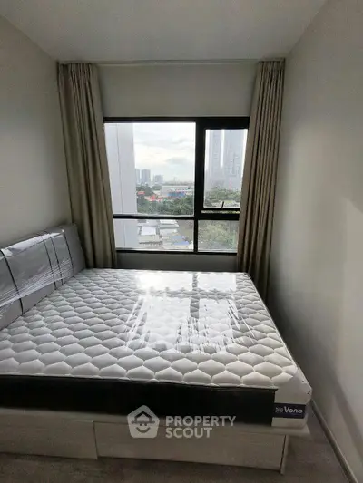 Modern bedroom with large window offering city view and natural light