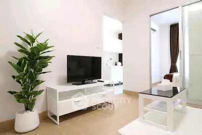 Modern minimalist living room with sleek furniture and a touch of greenery.