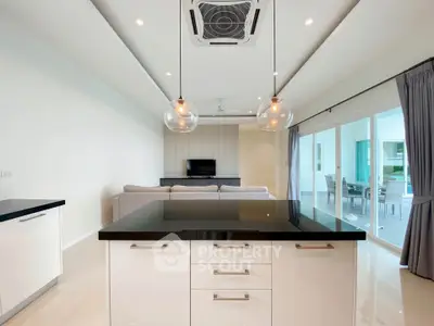 Modern open-plan living room with sleek kitchen island and stylish lighting