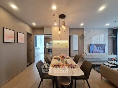 Luxurious open-plan living and dining area with elegant decor and modern lighting.