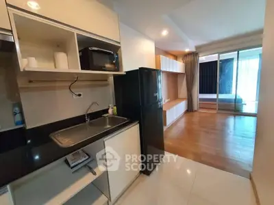 Modern open-layout kitchen with sleek appliances and spacious living area in a stylish apartment.