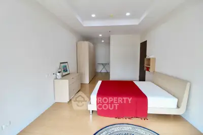 Spacious modern bedroom with minimalist design and red accents