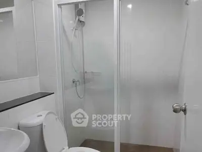 Modern bathroom with glass shower enclosure and sleek fixtures.