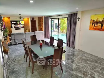 Spacious living room with elegant dining area and pool view, perfect for modern family living.