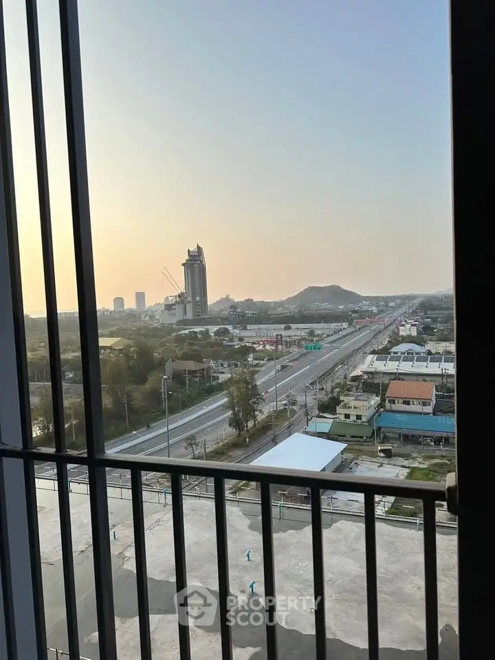 Stunning cityscape view from a high-rise balcony overlooking urban skyline and distant hills.