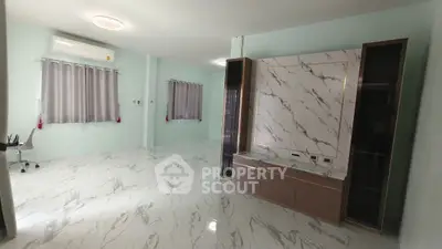 Spacious modern living room with marble accents and ample natural light.