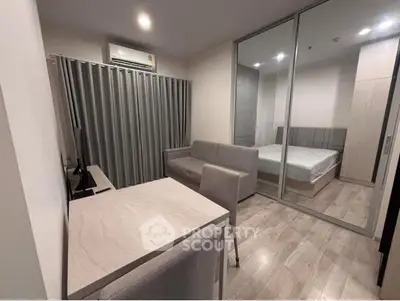 Modern studio apartment with sleek design and glass partition separating bedroom from living area.