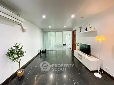 Spacious modern living room with sleek black flooring and stylish decor