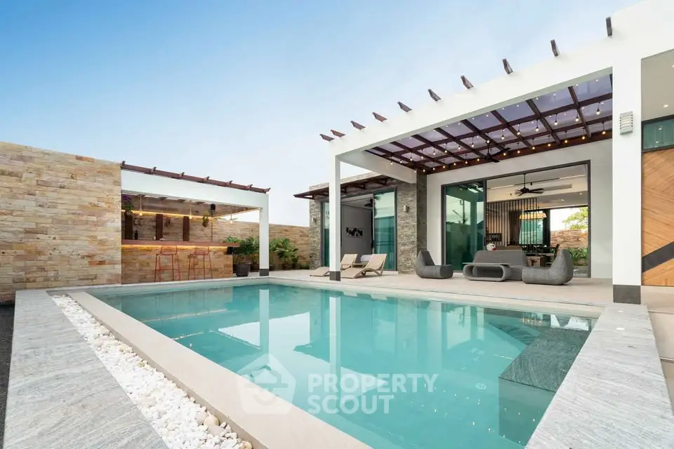 Luxurious modern villa with stunning pool and outdoor lounge area.