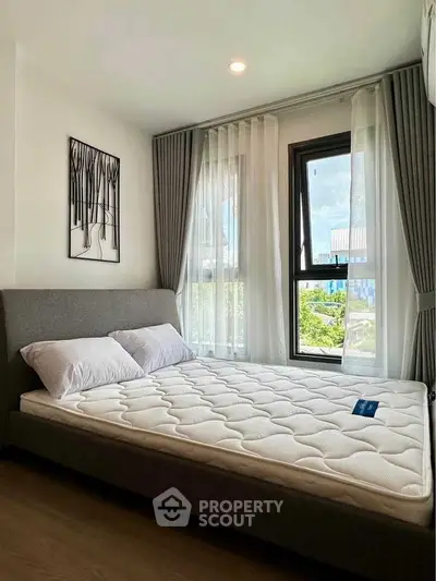 Modern bedroom with large windows and stylish decor in a bright apartment.