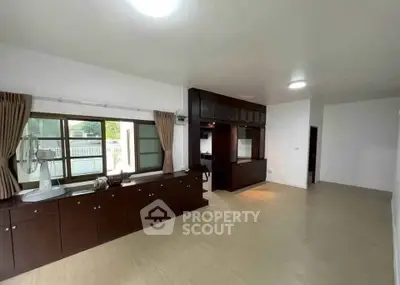 Spacious living room with wooden cabinets and large windows