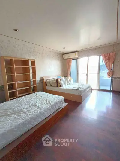 Spacious bedroom with two beds and balcony access in modern apartment