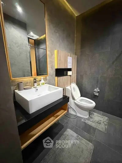 Modern bathroom with sleek design, featuring a stylish sink and toilet, perfect for contemporary living.