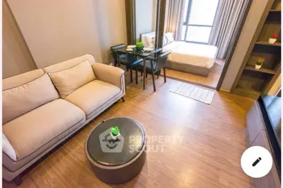 Modern studio apartment with cozy living area and bedroom, featuring stylish furniture and wooden flooring.